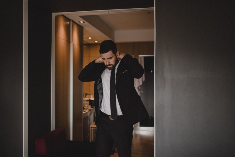 groom putting on his tie