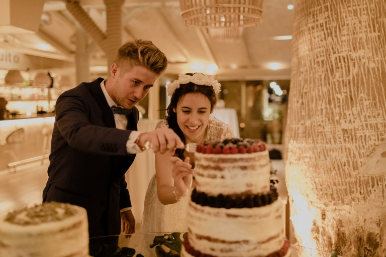 the wedding couple cutting the cake
