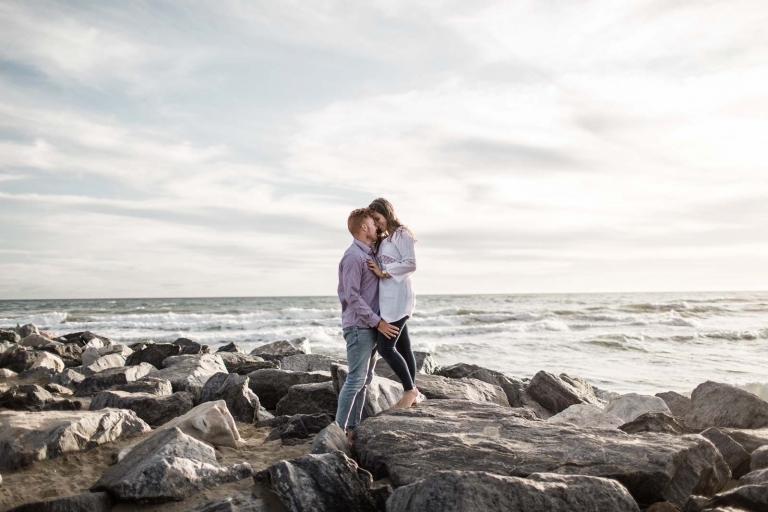couple standing on rock hugging each other